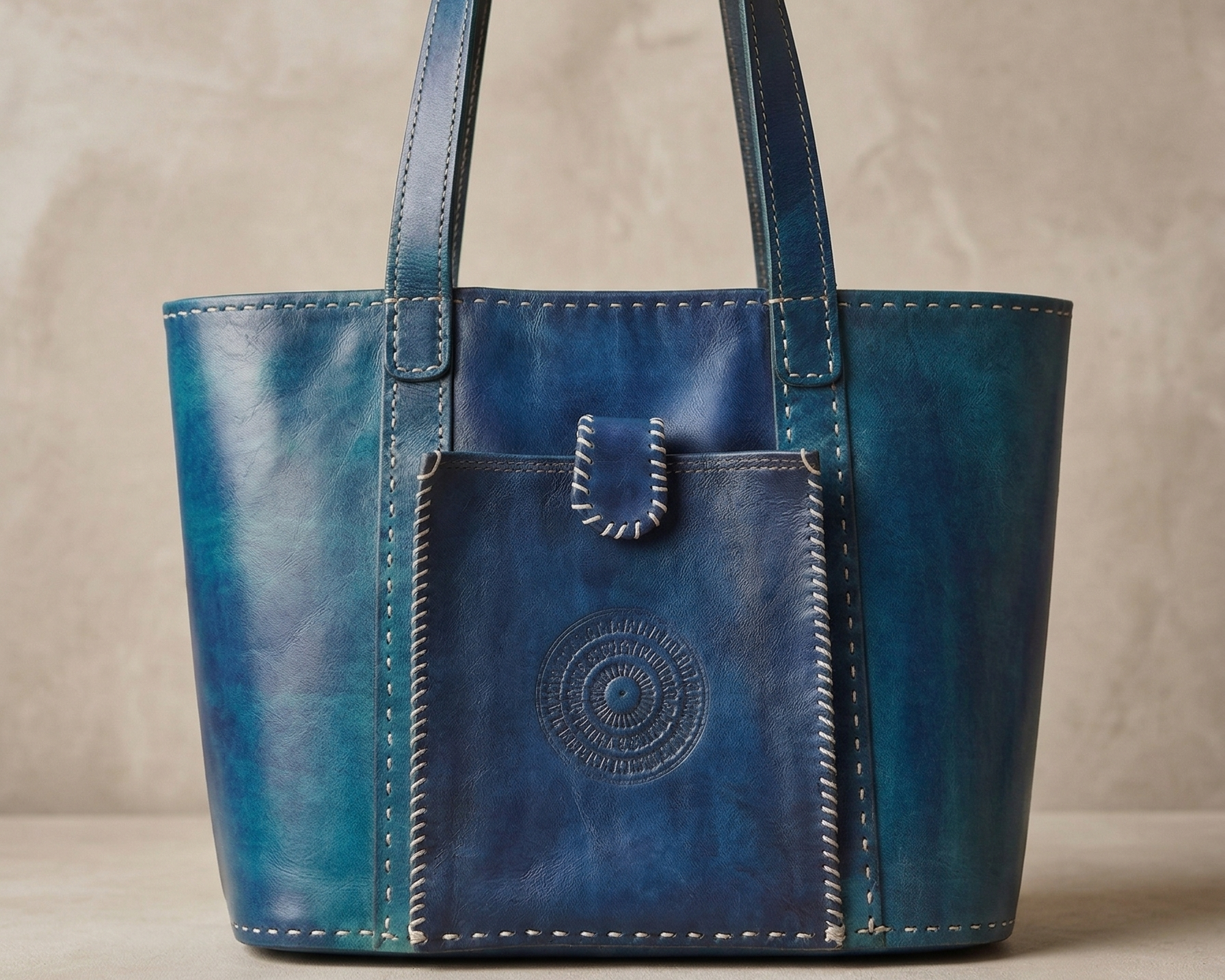 Blue leather handbag with a pocket on a beige background